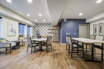 A dining room with tables and chairs and a kitchen